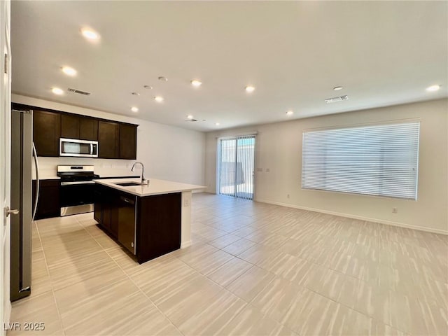 8003 Adelaide Hills St, Las Vegas, NV 89113 - kitchen with stainless steel appliances, open floor plan, an island with sink, recessed lighting, and light countertops