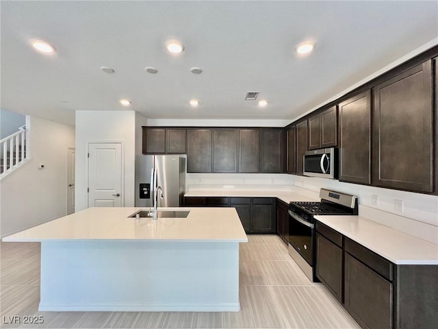 8003 Adelaide Hills St, Las Vegas, NV 89113 - kitchen with appliances with stainless steel finishes, a kitchen island with sink, dark brown cabinets, light countertops, and recessed lighting