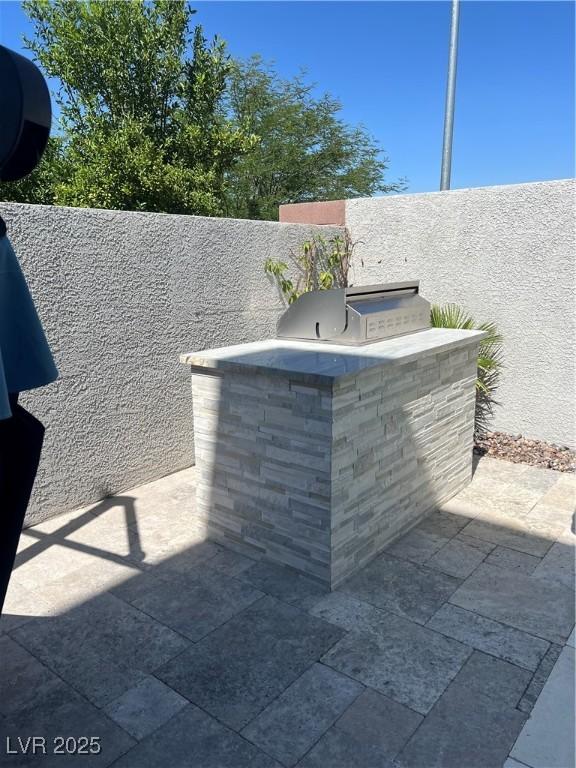 8094 Noble Ridge St, Las Vegas, NV 89139 - fenced backyard featuring an outdoor kitchen and a patio