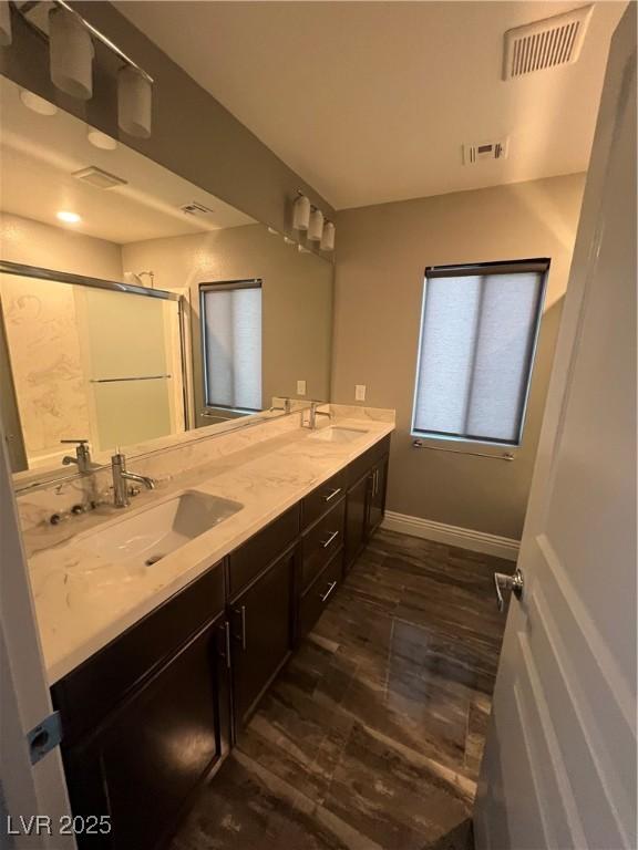 8094 Noble Ridge St, Las Vegas, NV 89139 - bathroom with double vanity, a shower, and wood finished floors