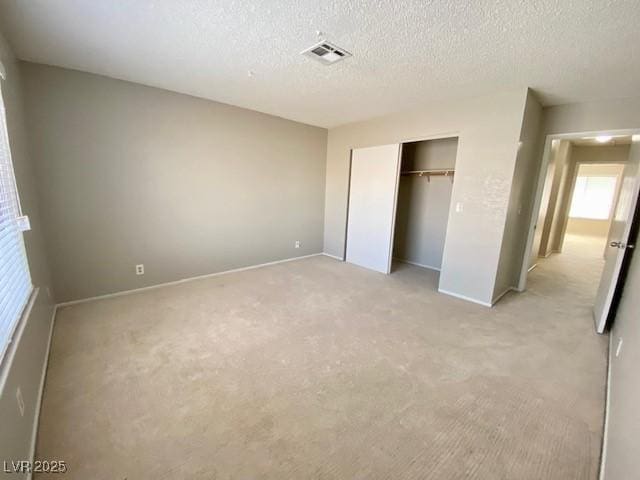 4242 Mississippi Ave, Las Vegas, NV 89103 - unfurnished bedroom featuring light colored carpet, a closet, and a textured ceiling