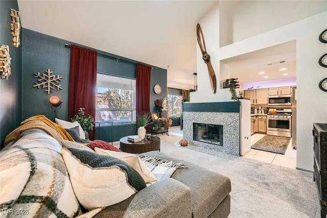 2133 Desert Pines St, Las Vegas, NV 89134 - living room featuring a towering ceiling, light carpet, a tiled fireplace, and light tile patterned floors