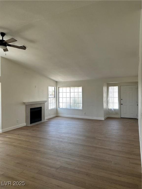 3160 James A Bilbray Pkwy, Laughlin, NV 89029 - unfurnished living room with plenty of natural light, a fireplace, a ceiling fan, wood finished floors, and vaulted ceiling