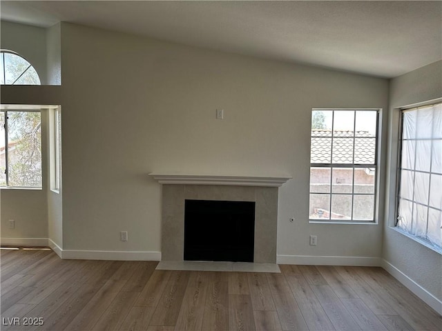 3160 James A Bilbray Pkwy, Laughlin, NV 89029 - unfurnished living room with wood finished floors, healthy amount of natural light, and a fireplace with flush hearth