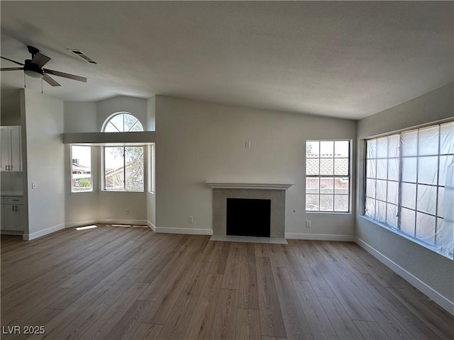 3160 James A Bilbray Pkwy, Laughlin, NV 89029 - unfurnished living room with vaulted ceiling, wood finished floors, a ceiling fan, and a fireplace with flush hearth