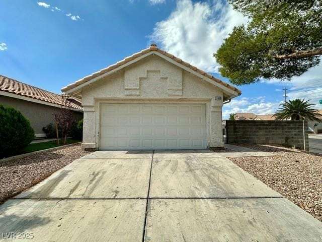 5400 Maddox Ave, Las Vegas, NV 89107 - view of front facade with a garage, stucco siding, concrete driveway, and a tiled roof