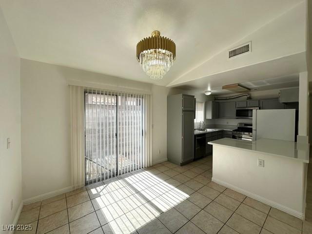 5400 Maddox Ave, Las Vegas, NV 89107 - kitchen featuring stainless steel appliances, a peninsula, light tile patterned floors, gray cabinetry, and a chandelier