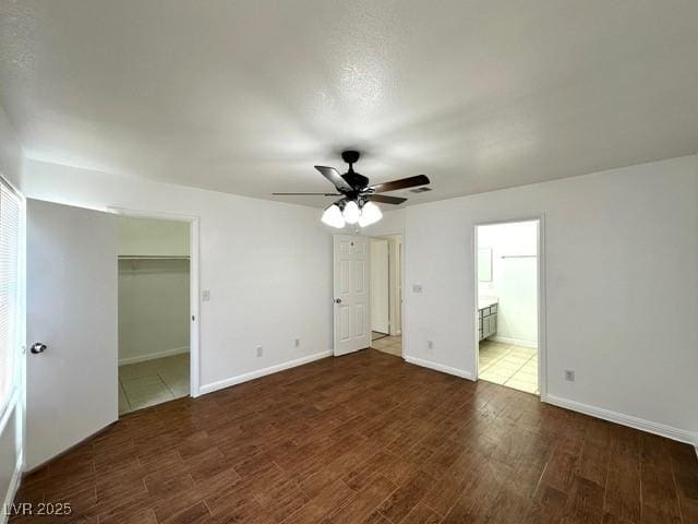 5400 Maddox Ave, Las Vegas, NV 89107 - unfurnished bedroom featuring wood finished floors, a spacious closet, a ceiling fan, and ensuite bathroom