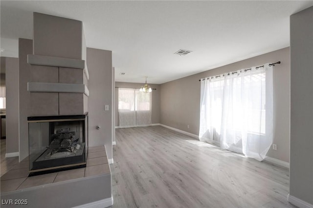 5204 Padua Way, Las Vegas, NV 89107 - unfurnished living room with a chandelier, wood finished floors, and a multi sided fireplace