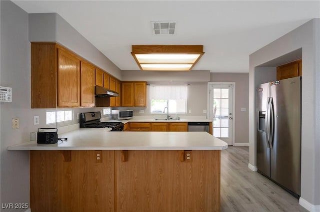 5204 Padua Way, Las Vegas, NV 89107 - kitchen featuring appliances with stainless steel finishes, under cabinet range hood, a peninsula, light countertops, and light wood-type flooring