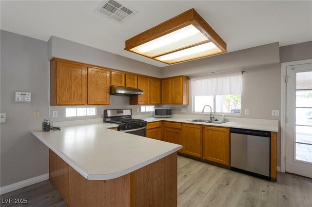5204 Padua Way, Las Vegas, NV 89107 - kitchen featuring appliances with stainless steel finishes, under cabinet range hood, light countertops, and a peninsula