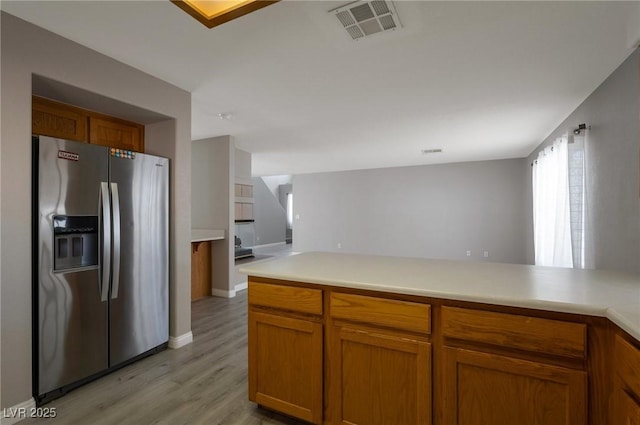 5204 Padua Way, Las Vegas, NV 89107 - kitchen featuring stainless steel fridge with ice dispenser, light wood-style flooring, light countertops, and brown cabinets