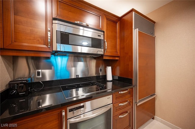135 E Harmon Ave Unit 414, Las Vegas, NV 89109 - kitchen featuring appliances with stainless steel finishes, brown cabinets, and dark countertops