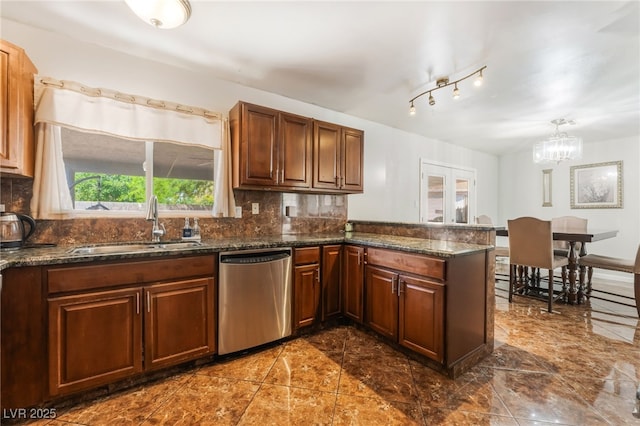 170 Palisade Ave, Las Vegas, NV 89110 - kitchen with stainless steel dishwasher, decorative backsplash, a peninsula, dark stone counters, and a chandelier