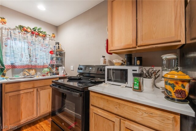 170 Palisade Ave, Las Vegas, NV 89110 - kitchen with black range with electric cooktop, white microwave, and light wood-style flooring