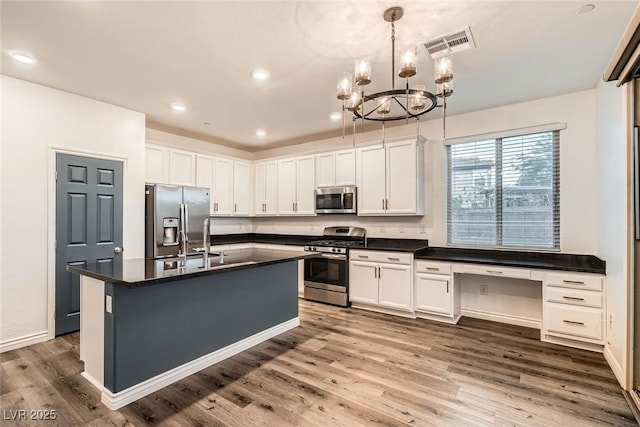 1009 Bluebell Brook St, Henderson, NV 89052 - kitchen with appliances with stainless steel finishes, dark countertops, white cabinetry, wood finished floors, and recessed lighting