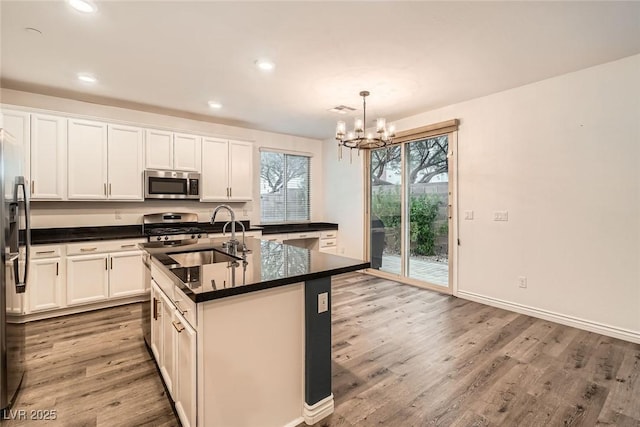 1009 Bluebell Brook St, Henderson, NV 89052 - kitchen with appliances with stainless steel finishes, dark countertops, wood finished floors, a chandelier, and recessed lighting