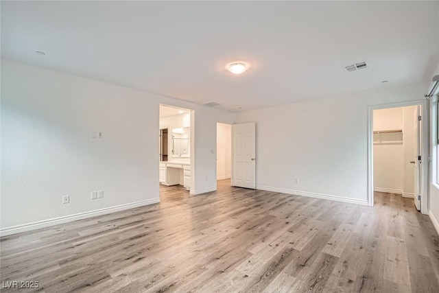 1009 Bluebell Brook St, Henderson, NV 89052 - unfurnished bedroom featuring light wood finished floors, a spacious closet, ensuite bath, and a closet