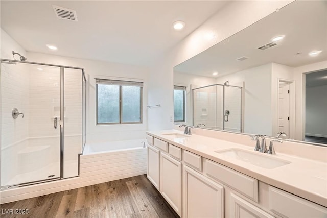 1009 Bluebell Brook St, Henderson, NV 89052 - full bathroom with a shower stall, double vanity, a bath, wood finished floors, and recessed lighting
