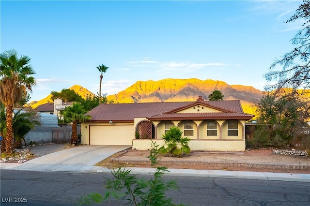 744 Milstead Ct, Las Vegas, NV 89110 - view of front facade with a mountain view, a garage, concrete driveway, stucco siding, and a tile roof