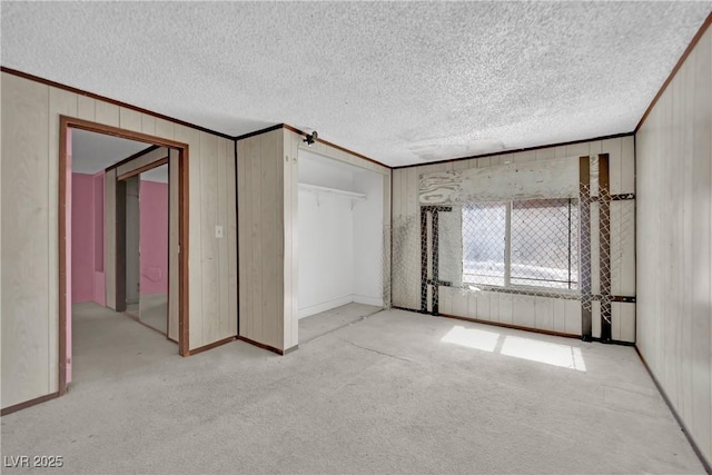 3009 Merritt Ave, Las Vegas, NV 89102 - unfurnished bedroom featuring carpet flooring, a textured ceiling, wooden walls, a closet, and crown molding