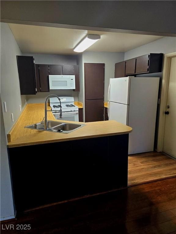123 Sirnoble St, Las Vegas, NV 89110 - kitchen featuring white appliances, a peninsula, wood finished floors, and light countertops