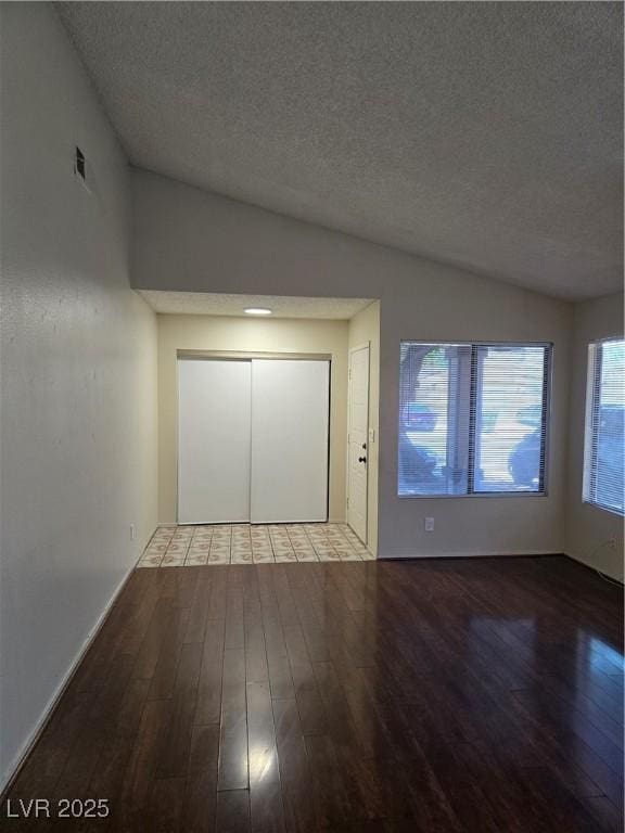 123 Sirnoble St, Las Vegas, NV 89110 - unfurnished bedroom with wood finished floors, a textured ceiling, vaulted ceiling, and a closet