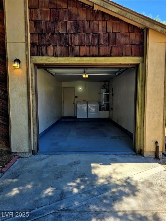 123 Sirnoble St, Las Vegas, NV 89110 - garage with strapped water heater, washing machine and dryer, and driveway