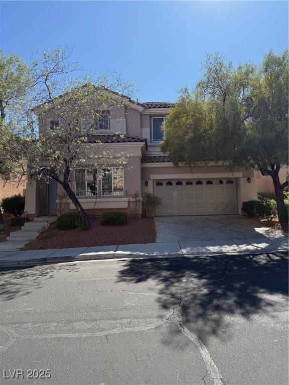 561 Tecate Valley St, Las Vegas, NV 89138 - view of front of house featuring driveway, stucco siding, a tile roof, and an attached garage