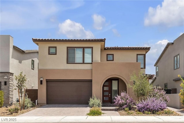 1309 Azure Jay Ave, North Las Vegas, NV 89084 - mediterranean / spanish-style home featuring an attached garage, stucco siding, decorative driveway, and a tiled roof