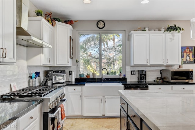 10960 Bethel Park Ct, Las Vegas, NV 89141 - kitchen featuring stainless steel appliances, wall chimney range hood, white cabinets, tasteful backsplash, and recessed lighting