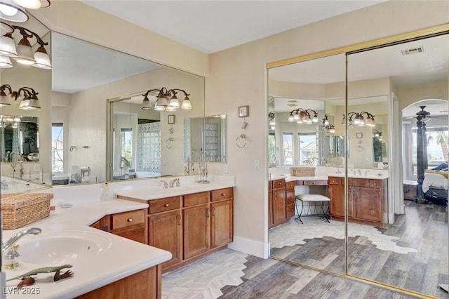 10960 Bethel Park Ct, Las Vegas, NV 89141 - bathroom featuring ensuite bathroom, wood finished floors, two vanities, and a chandelier