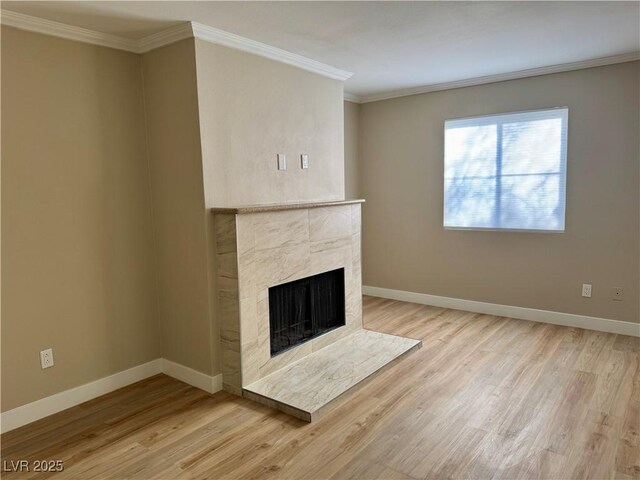 8600 W Charleston Blvd Unit 2161, Las Vegas, NV 89117 - unfurnished living room featuring light wood-type flooring, crown molding, and a tiled fireplace