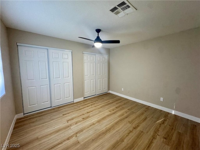 8600 W Charleston Blvd Unit 2161, Las Vegas, NV 89117 - unfurnished bedroom with multiple closets, light wood-type flooring, and a ceiling fan