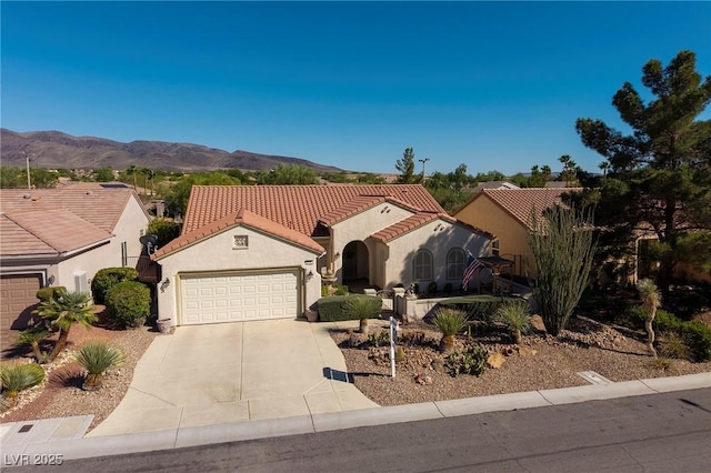 2559 Deora Way, Henderson, NV 89052 - mediterranean / spanish-style house with driveway, an attached garage, a mountain view, stucco siding, and a tile roof