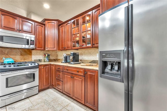 1971 Del Font Ct, Las Vegas, NV 89117 - kitchen with stainless steel appliances, tasteful backsplash, glass insert cabinets, light stone countertops, and recessed lighting