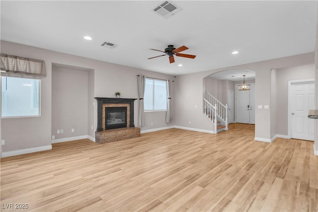 5001 Pounding Surf Ave, Las Vegas, NV 89131 - unfurnished living room featuring arched walkways, light wood-style flooring, a fireplace, ceiling fan, and recessed lighting
