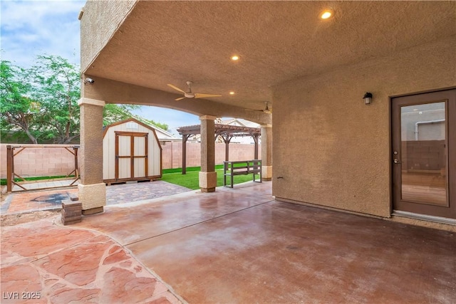 5001 Pounding Surf Ave, Las Vegas, NV 89131 - fenced backyard featuring a storage unit, a patio, and a ceiling fan