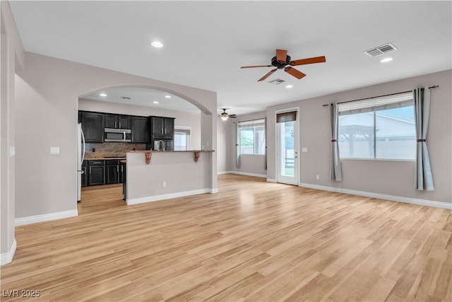 5001 Pounding Surf Ave, Las Vegas, NV 89131 - unfurnished living room featuring ceiling fan, light wood finished floors, recessed lighting, and arched walkways