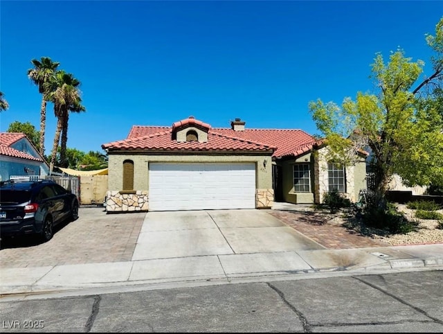 4216 Famoso Dr, North Las Vegas, NV 89032 - mediterranean / spanish home with stone siding, stucco siding, a tile roof, and an attached garage