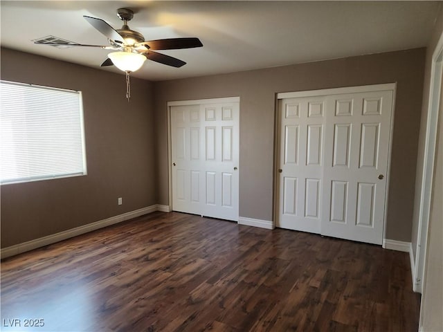 161 Diamond Bar Rd, Pahrump, NV 89048 - unfurnished bedroom with two closets, dark wood-type flooring, and a ceiling fan