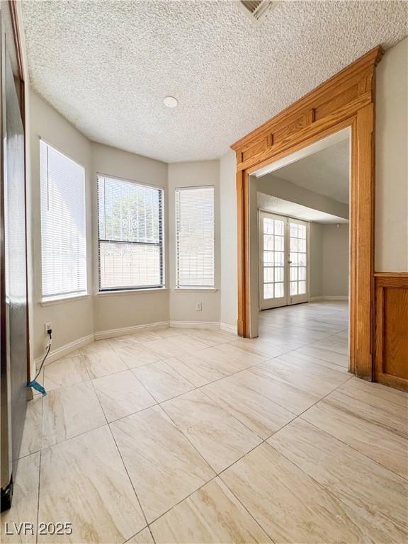 6437 Peachwood Rd, Las Vegas, NV 89108 - unfurnished room with a textured ceiling and french doors