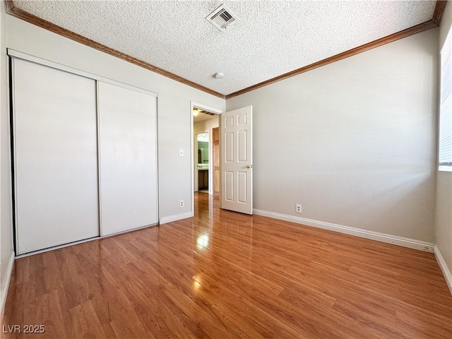6437 Peachwood Rd, Las Vegas, NV 89108 - unfurnished bedroom featuring a textured ceiling, wood finished floors, a closet, and ornamental molding