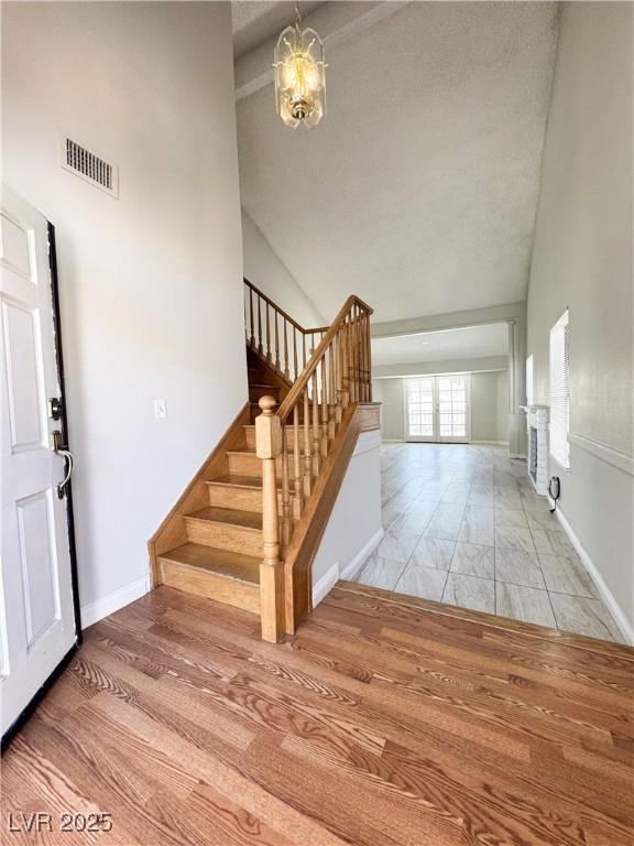 6437 Peachwood Rd, Las Vegas, NV 89108 - stairs with high vaulted ceiling and a chandelier