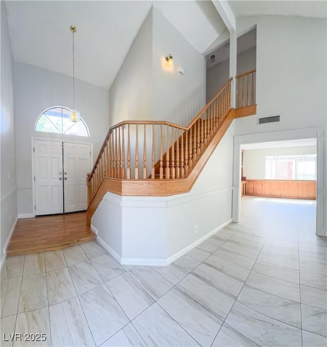 6437 Peachwood Rd, Las Vegas, NV 89108 - foyer entrance featuring stairs, high vaulted ceiling, healthy amount of natural light, marble look tiles, and beam ceiling