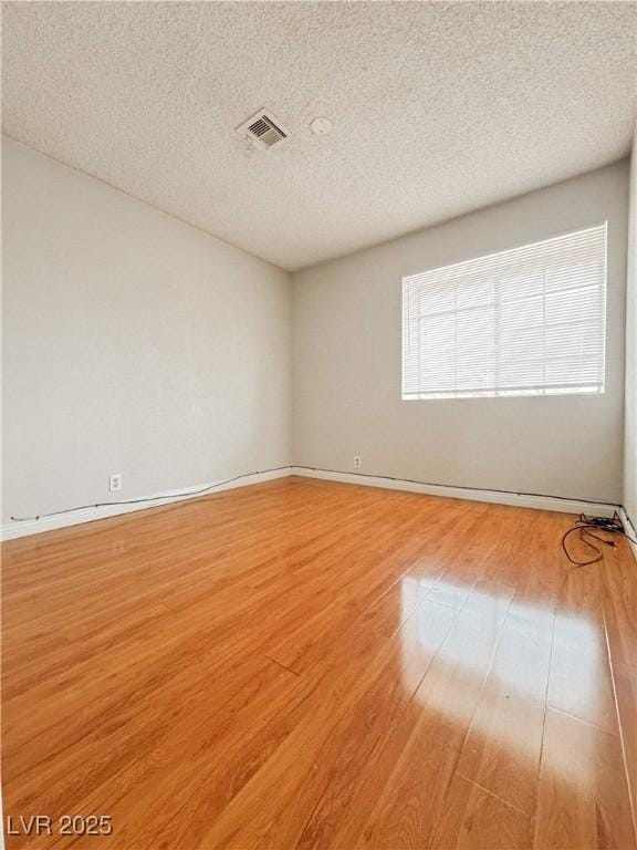 6437 Peachwood Rd, Las Vegas, NV 89108 - empty room featuring light wood finished floors and a textured ceiling