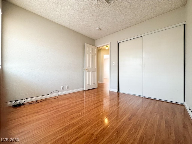 6437 Peachwood Rd, Las Vegas, NV 89108 - unfurnished bedroom featuring wood finished floors, a textured ceiling, and a closet