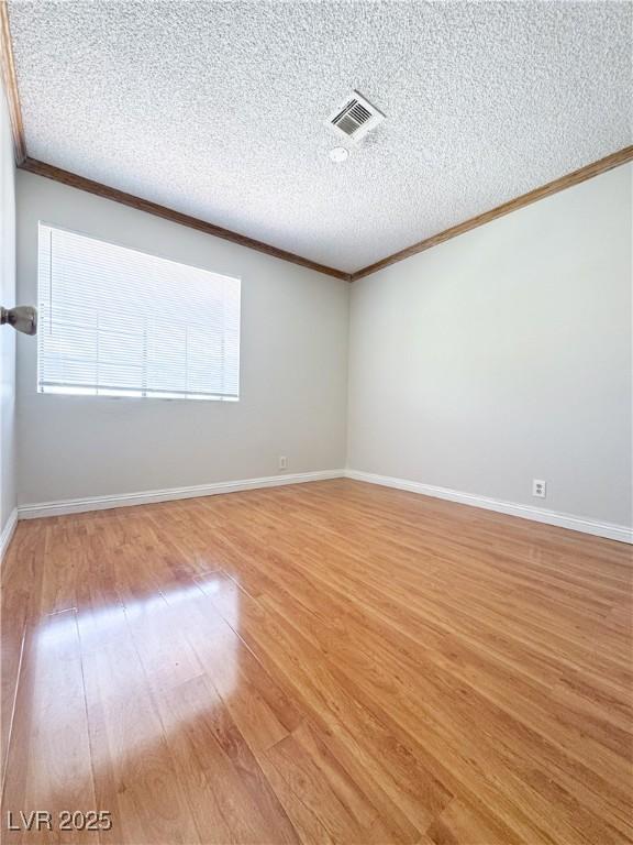 6437 Peachwood Rd, Las Vegas, NV 89108 - spare room with ornamental molding, light wood-style floors, and a textured ceiling