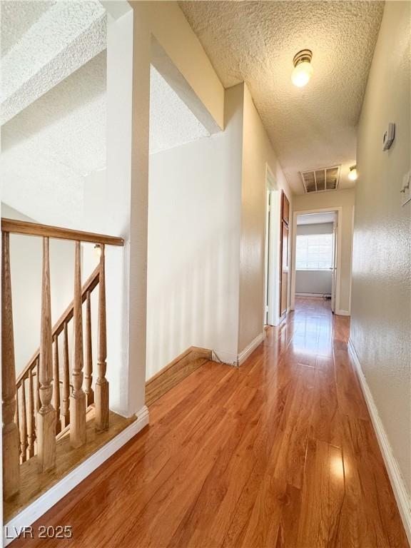 6437 Peachwood Rd, Las Vegas, NV 89108 - hall featuring wood finished floors and a textured ceiling