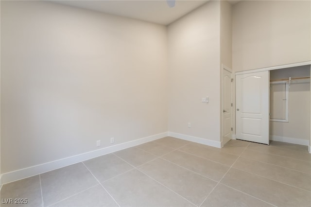 9332 Sienna Vista Dr, Las Vegas, NV 89117 - unfurnished bedroom with light tile patterned floors, a closet, and a high ceiling